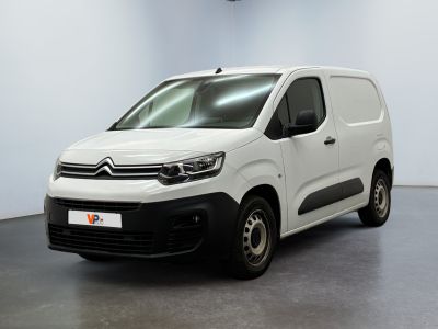 une camionnette blanche garée dans une pièce aux murs blancs