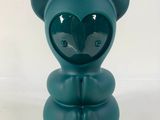 un petit ours bleu avec un cœur sur la tête