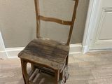 une chaise en bois posée dans un coin d'une pièce