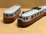 deux trains miniatures posés l'un à côté de l'autre sur une table