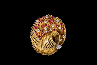 un gros plan d'une bague en or et diamants sur fond noir