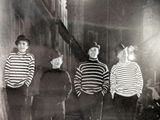 black and white photograph of three men in striped shirts standing next to each other