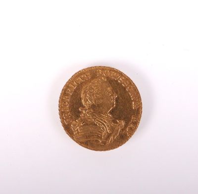 gros plan d'une pièce d'or sur une surface blanche