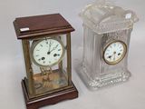 two clocks sitting next to each other on a table