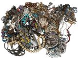 a pile of assorted necklaces and bracelets on a white surface