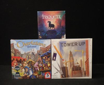 trois jeux de société posés sur une table