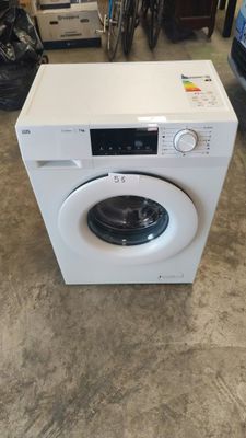 une machine à laver blanche posée sur le sol d'une pièce