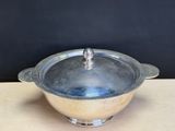 a silver bowl with a lid sitting on a table