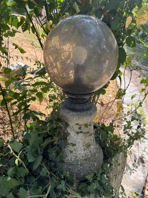 une boule de pierre posée sur un socle en pierre
