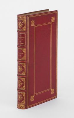 un vieux livre avec une couverture rouge et des bordures dorées sur fond blanc