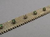 un gros plan d'un bracelet en argent orné de perles vertes