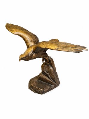 une image représentant une statue en bronze d'un oiseau posé sur un rocher
