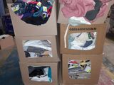 deux cartons sur lesquels sont posés des vêtements, dans un entrepôt