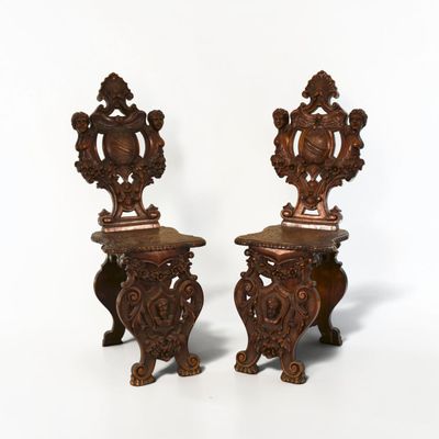 pair of antique carved wood chairs with ornate carvings on them