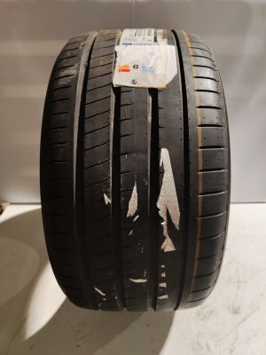 un gros plan d'un pneu posé sur une table, sur lequel est collé un autocollant