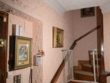 une photo d'un escalier dans une maison avec des tableaux accrochés au mur
