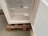 a white refrigerator with a door open on a pallet