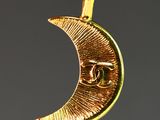 a close up of a gold crescent with a eye on it