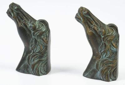 pair of bronze horse head bookends on a white background