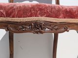a wooden bench with a red cushion on top of it