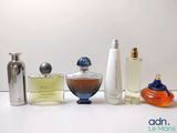 several different types of perfume bottles are lined up on a white surface