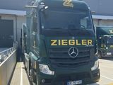 un camion vert garé devant un immeuble