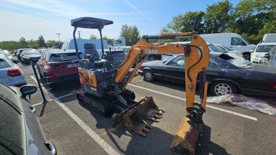 une petite excavatrice garée sur un parking