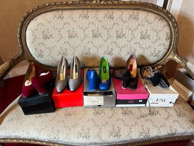 many pairs of shoes sitting on a chair in a room