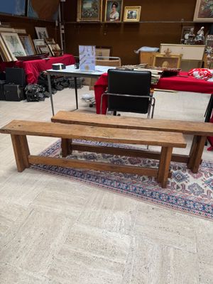 a wooden bench sitting in a room with a rug on the floor