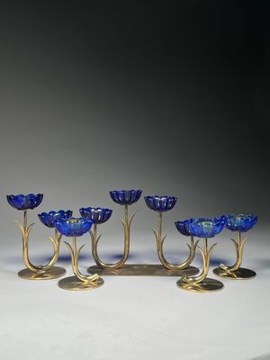 un ensemble de six bougeoirs en verre bleu et en laiton