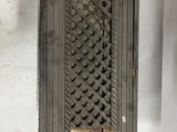 a metal box with a pattern on it hanging on the wall