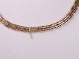necklace with gold - plated metal chain and clasp on a white surface