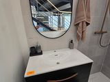 une salle de bains équipée d'un lavabo, d'une douche et d'un miroir