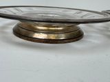 a glass bowl with a metal stand on a white surface