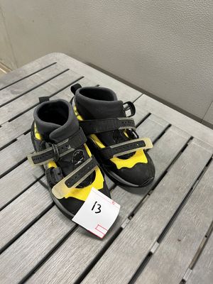 une paire de chaussures noires et jaunes posées sur une table en bois