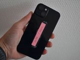 a person holding a cell phone with a pink sticker on it