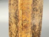 an old book sitting on top of a table next to a black table