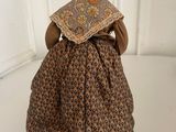 an old fashioned figurine of a woman in a dress and bonnet