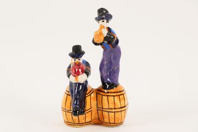 a figurine of a man and a woman sitting on a barrel
