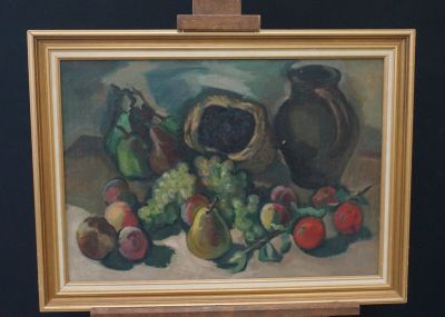 une peinture représentant une nature morte avec des fruits, posée sur un chevalet