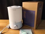 un petit humidificateur posé sur une table à côté d'une boîte