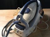 a white and blue steam iron on a wooden table