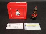 une boîte rouge sur laquelle se trouve une petite statuette