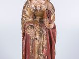 une vieille statue représentant une femme en robe rouge, assise sur une chaise