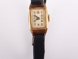 an image of a gold watch with a black strap
