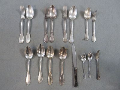 un grand nombre de cuillères et de fourchettes en argent disposées sur une table