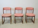 three pink chairs sitting next to each other in a room
