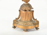 a gold vase on a stand on a white background
