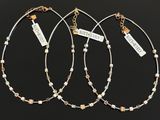 three silver and gold necklaces with charms and tags on them