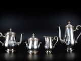 trois théières en argent et une cafetière sur fond noir